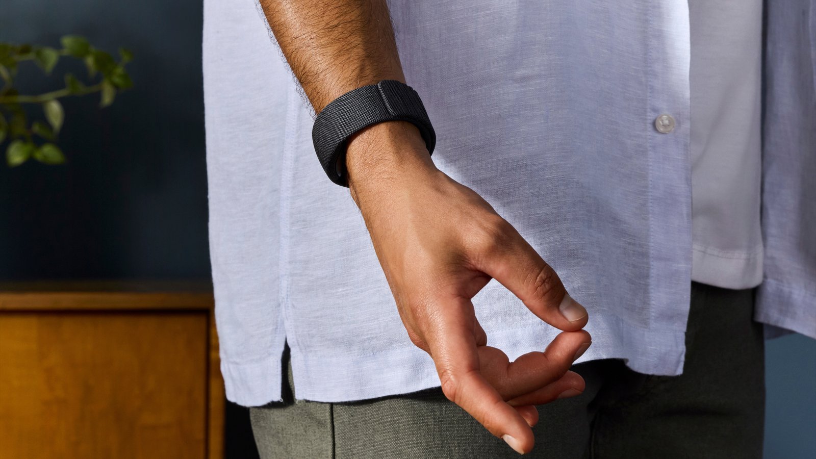 Press photo of Meta's Orion EMG wristband, with the wearer making a pinching gesture.