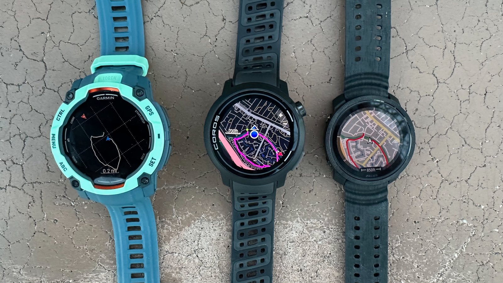 The Garmin Instinct 3 (left), COROS PACE Pro (center), and Polar Vantage M3 showing a mapped activity line; Garmin shows a breadcrumb trail with no offline map details, while the other two have actual streets