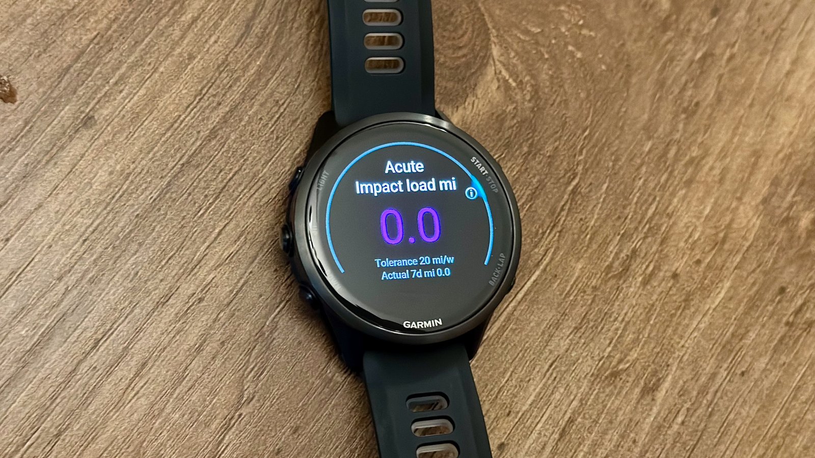The Garmin Forerunner 970 on a table showing my acute impact load miles (0) in the last seven days.