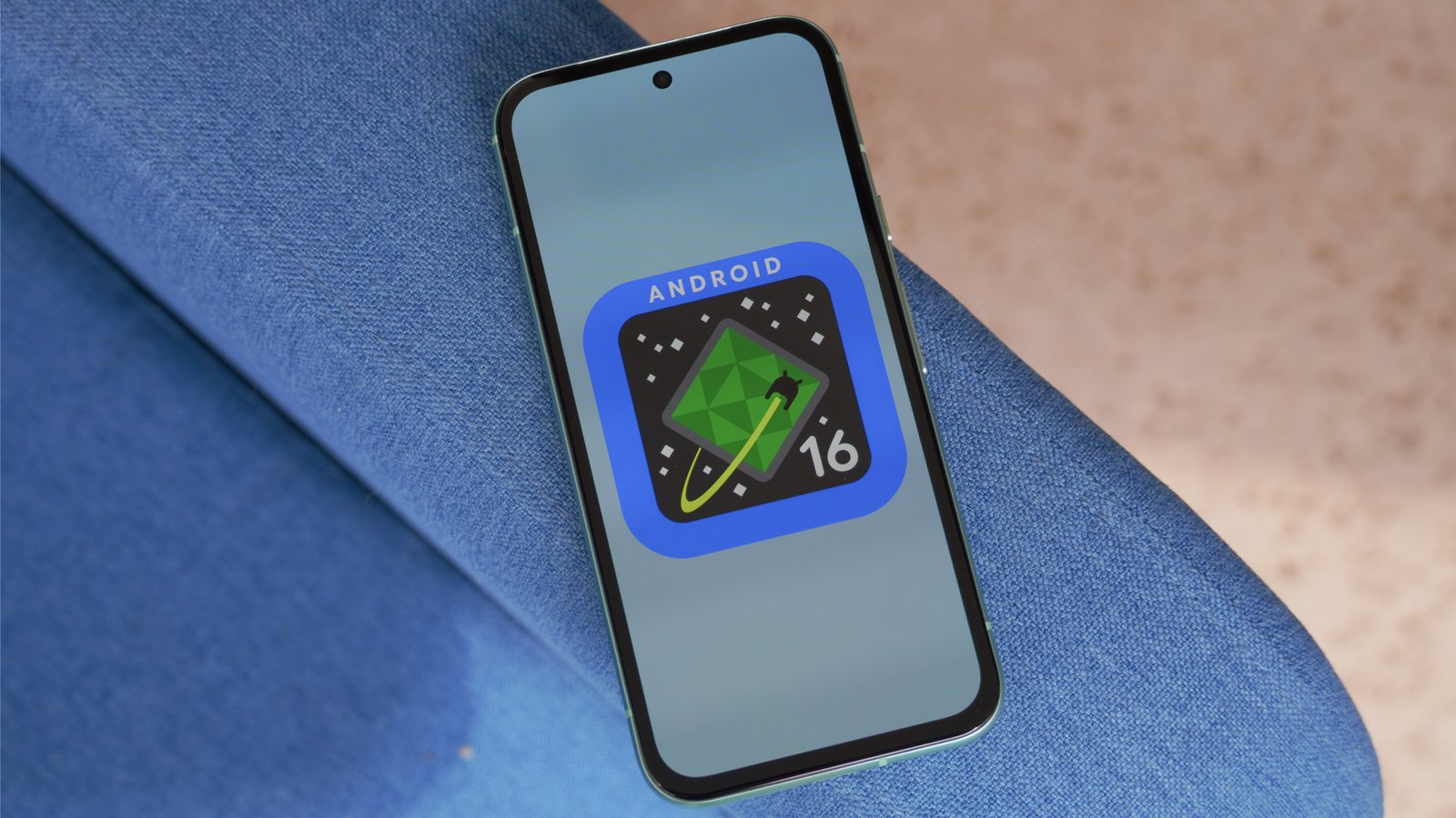 The Android 16 logo on a Google Pixel 8a outdoors.